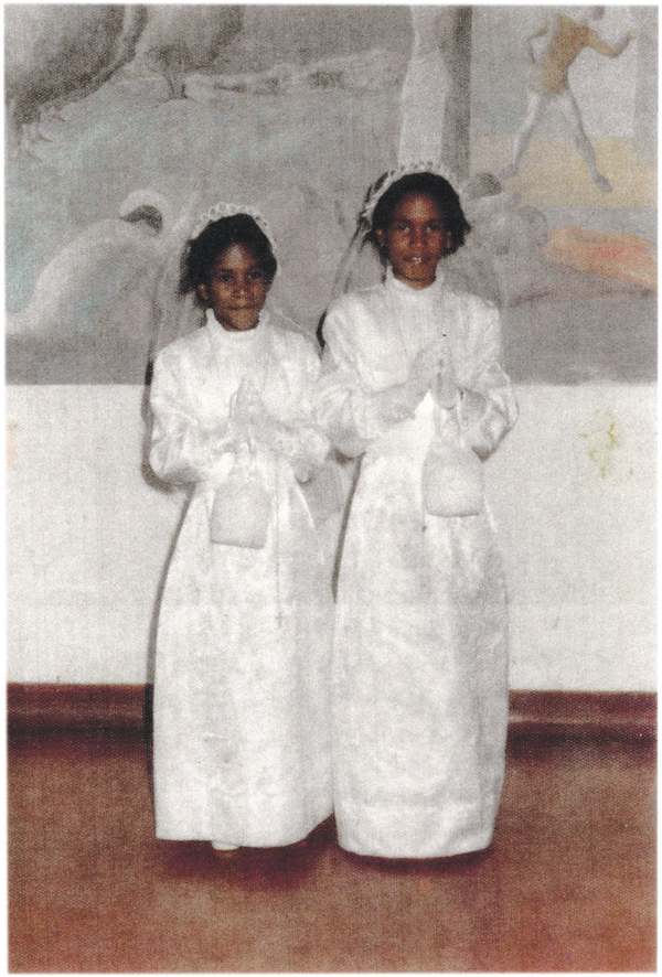 With her sister Catherine at their first communion in 1976 