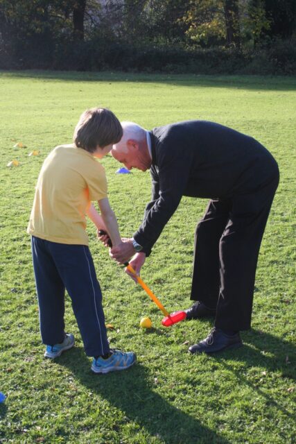 Cliff Heath teaches golf to a Grasmere Primary School pupil