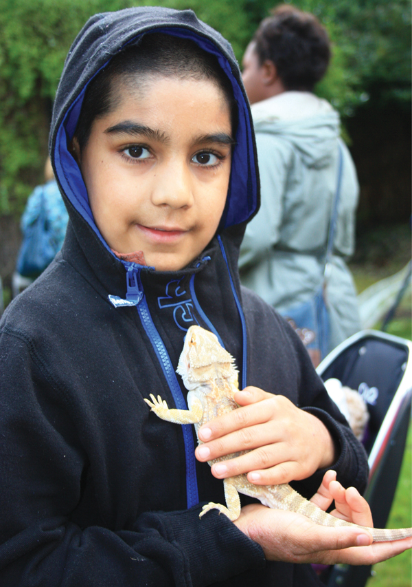 Year 4 pupil, Ahmar, holding a bearded dragon from the school's zoo