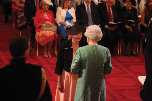 Dame Joan is made a Dame CBE by The Queen at Buckingham Palace. Below: investiture day with her two daughters, both teachers in London schools Photo: PA/Wire