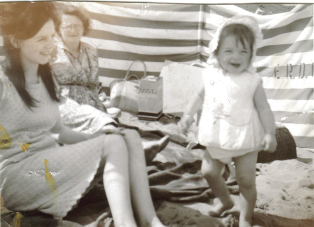 On the beach, with her mother and grandmother