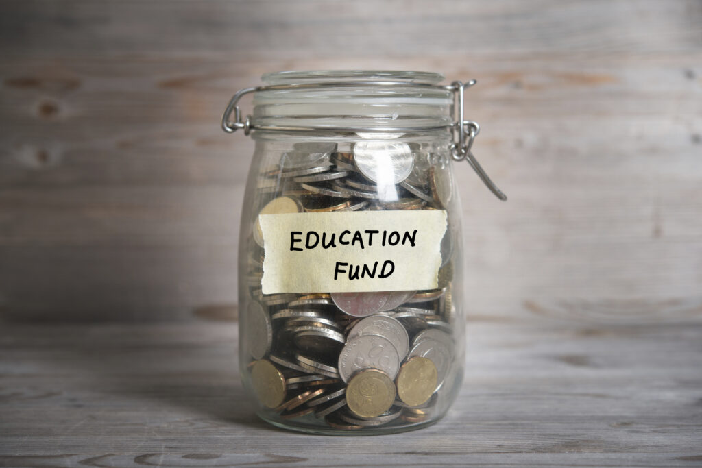 Money jar with education fund label. | Schools Week