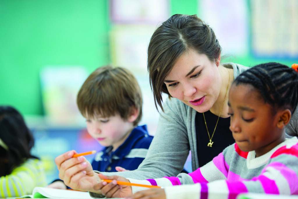 Teacher Helping a Student Understand an Assignment | Schools Week
