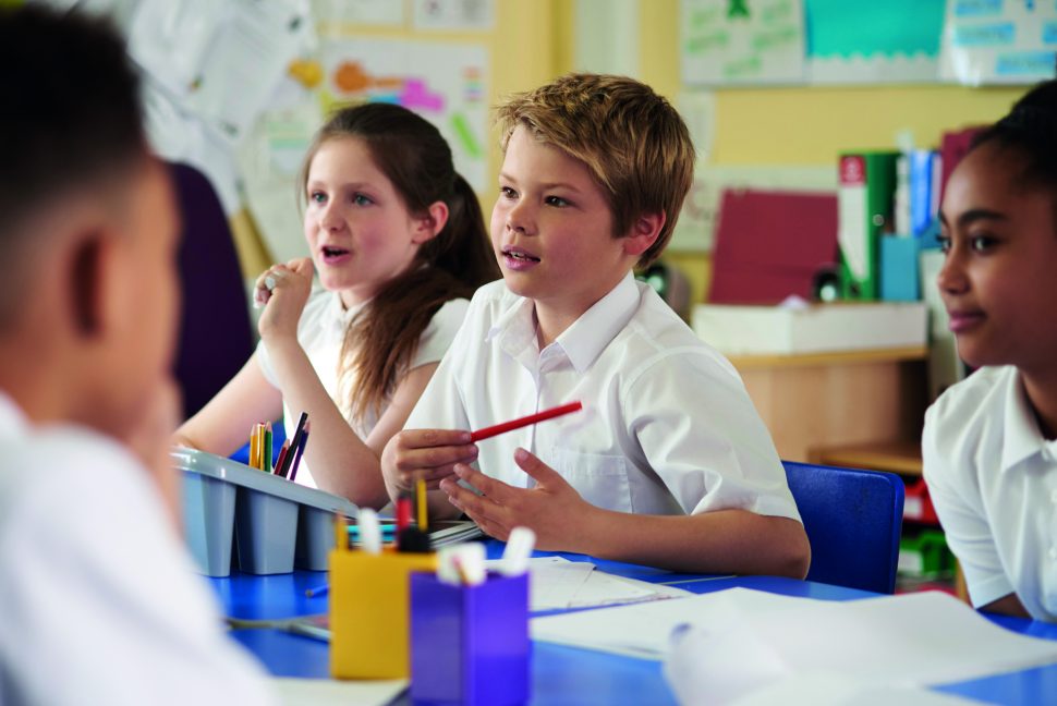 Primary school children work together in class, close up | Schools Week