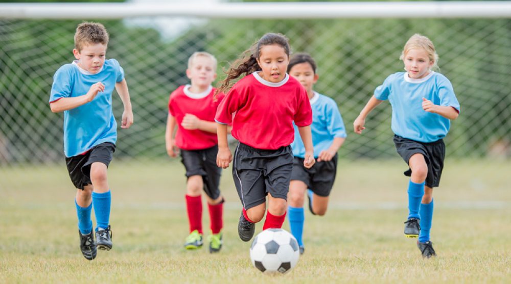 File image of girls and boys playing football at school